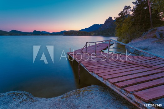 Picture of Wooden pier on a blue lake sunset and smooth reflection on water Long exposure Borovoye Lake Kazakhstan